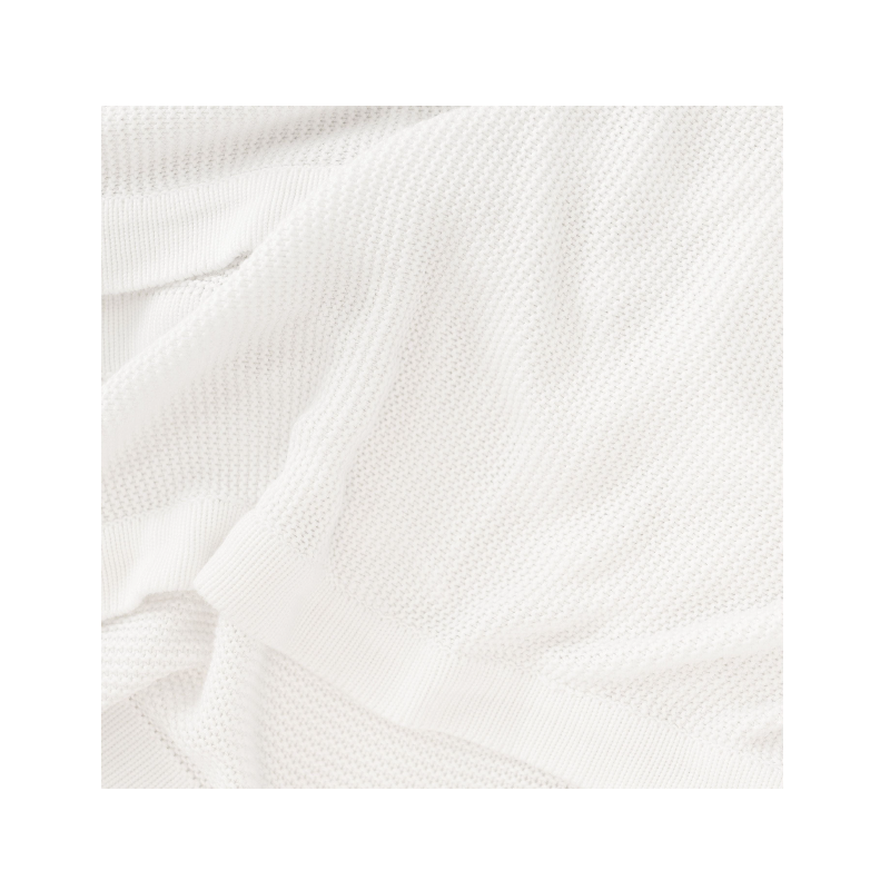 Ivory Cloud Knit Baby Blanket draped over crib |Color:Ivory