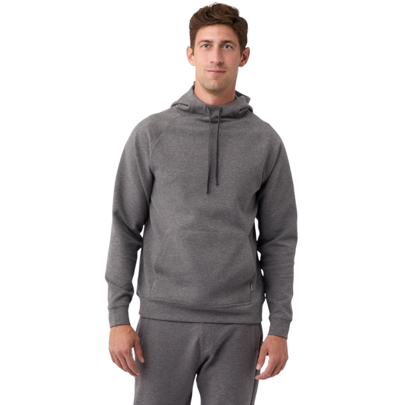 A person wearing the Men's StretchTech Hoodie from Cozy Earth, paired with matching gray pants, stands against a plain white background. The hoodie features drawstrings and a front pocket. The individual is looking forward with a neutral expression. |Color:Coal Heather