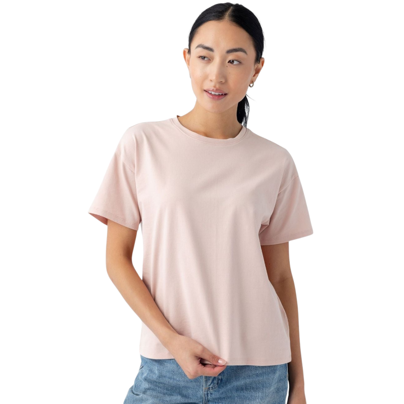 A person with long dark hair is wearing a light pink Women's All Day Tee from Cozy Earth and jeans. They are looking slightly to the side with a neutral expression, against a plain white background. |Color:Dusty Rose