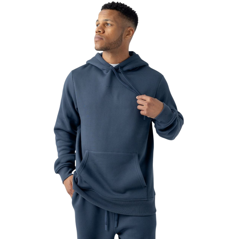 A man wearing a Cozy Earth Men's CityScape Hoodie and matching jogger pants stands against a white background. He is looking off to the side while casually holding the drawstring of his hoodie. |Color:Eclipse