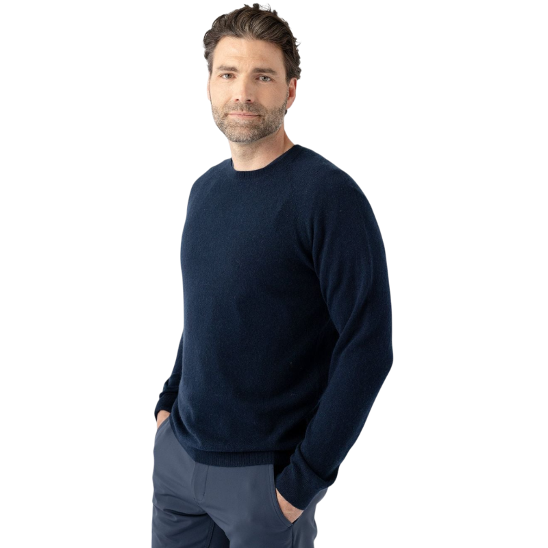 A man with dark hair and a beard stands casually with his hands in his pockets. He is wearing the Cozy Earth Men's Crewneck Sweater in navy blue, paired with gray pants. He looks at the camera with a neutral expression, set against a plain white background. |Color:Eclipse