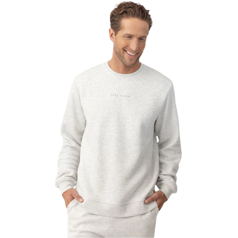 A young boy with short dark hair is wearing a light gray Kid's CityScape Crewneck by Cozy Earth. He is looking to the side with a slight smile against a plain white background. |Color:Heather Grey