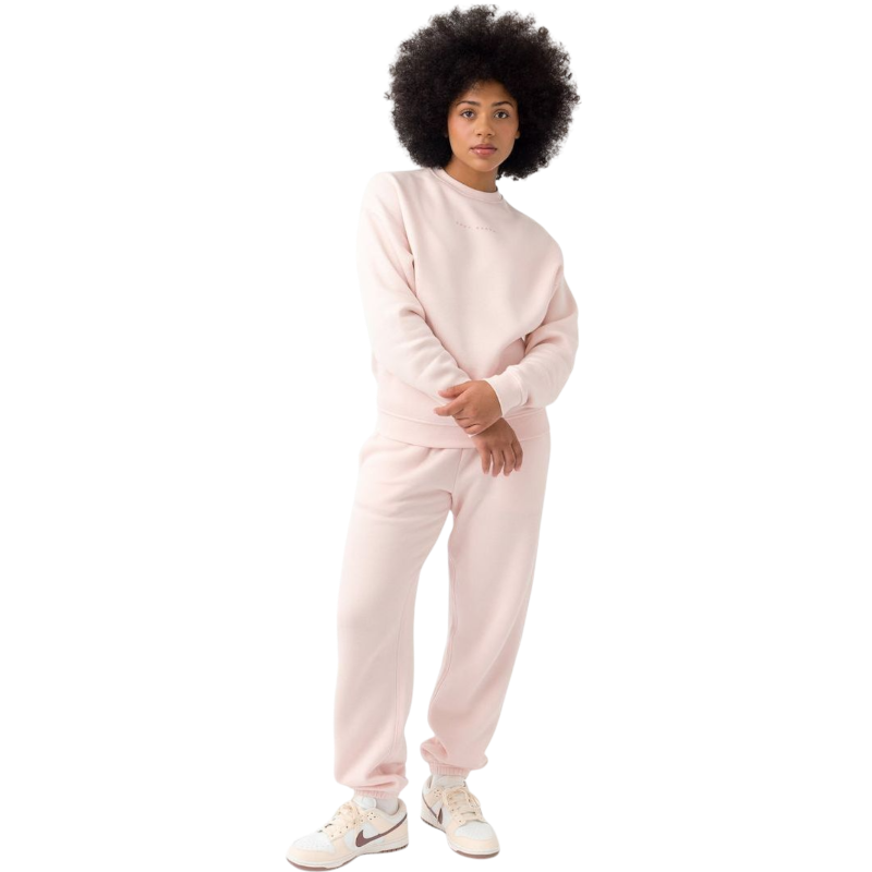 A person with curly hair models the Cozy Earth Women's CityScape Crewneck and matching pants in light pink against a plain white backdrop. |Color:Peony