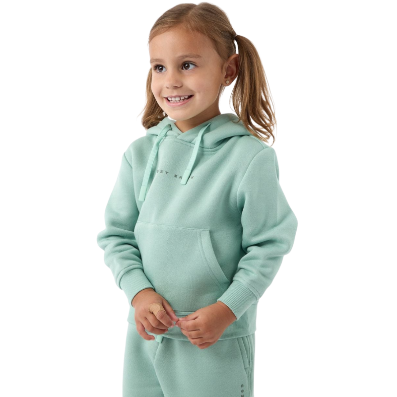 A young girl with light brown hair in pigtails smiles while wearing a mint green Kid's CityScape Hoodie and matching pants from Cozy Earth. She stands against a plain white background. |Color:Wintergreen
