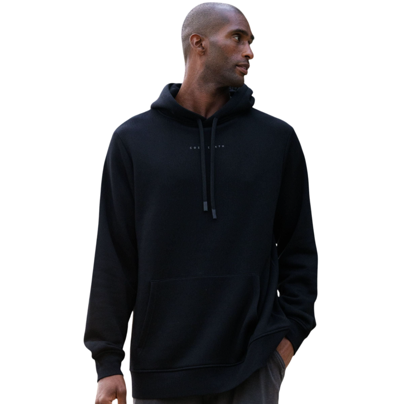 A person with curly hair is wearing a Cozy Earth Men's CityScape Hoodie in dark green and standing against a plain white background, with their hands together. |Color:Spruce