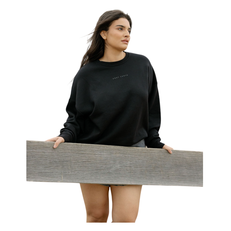 A person with curly hair models the Cozy Earth Women's CityScape Crewneck and matching pants in light pink against a plain white backdrop. |Color:Peony