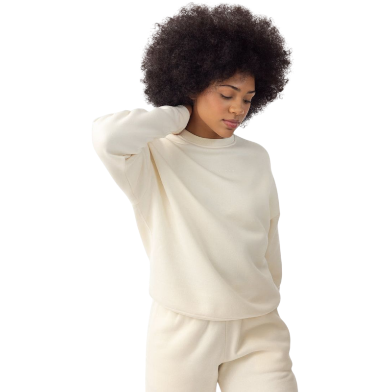 A person with curly hair models the Cozy Earth Women's CityScape Crewneck and matching pants in light pink against a plain white backdrop. |Color:Peony