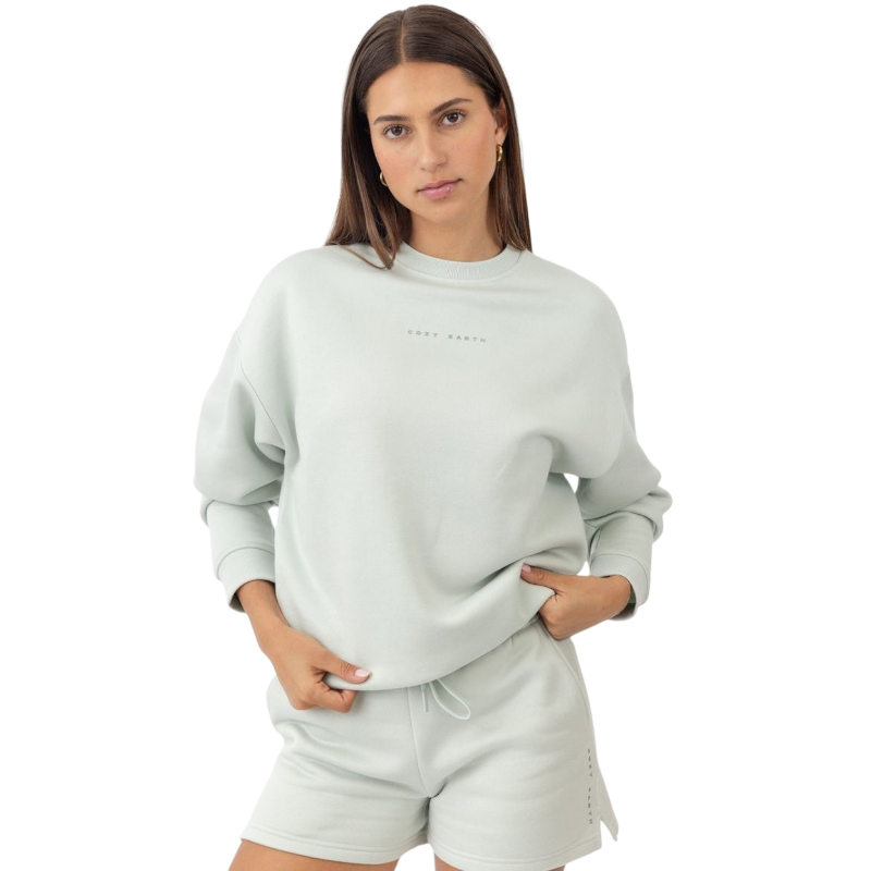 Arctic CityScape Pullover Crew. The Pullover is being worn by a female model. Accompanying city scape clothing is being worn to complete the look of the outfit. The photo was taken with a white background. |Color:Arctic