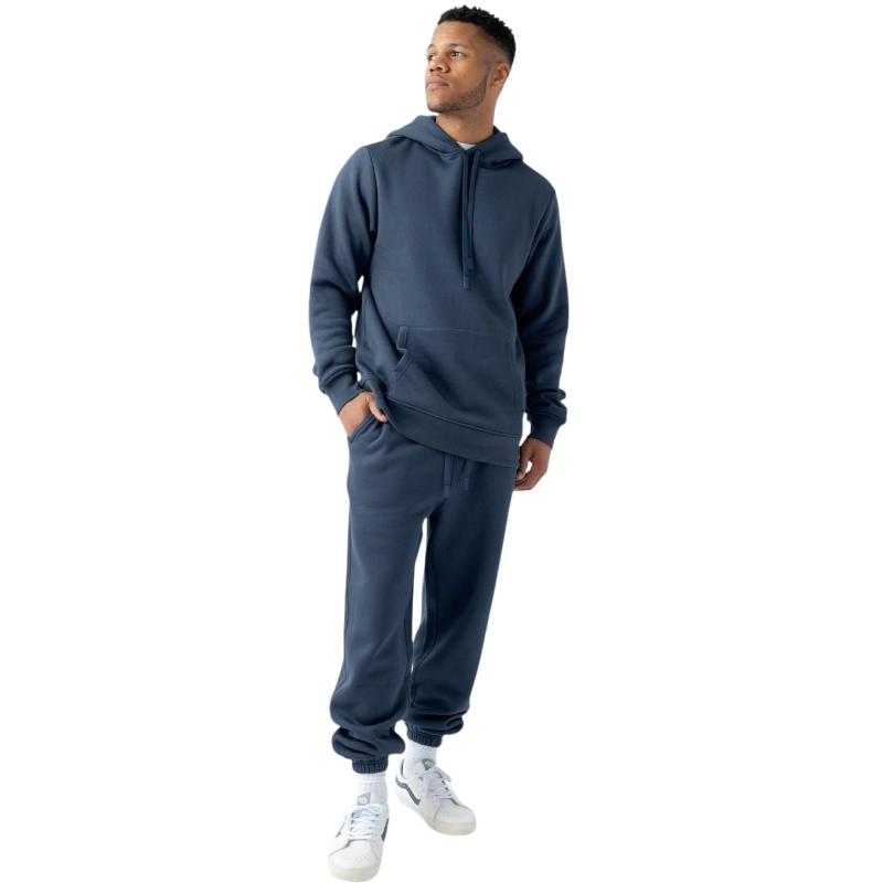 A person with curly hair is wearing a Cozy Earth Men's CityScape Hoodie in dark green and standing against a plain white background, with their hands together. |Color:Spruce