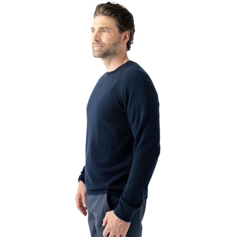 A man with dark hair and a beard stands casually with his hands in his pockets. He is wearing the Cozy Earth Men's Crewneck Sweater in navy blue, paired with gray pants. He looks at the camera with a neutral expression, set against a plain white background. |Color:Eclipse
