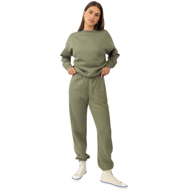 A person with curly hair models the Cozy Earth Women's CityScape Crewneck and matching pants in light pink against a plain white backdrop. |Color:Peony