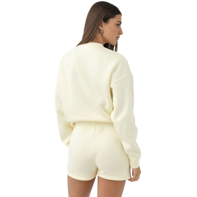 A person with curly hair models the Cozy Earth Women's CityScape Crewneck and matching pants in light pink against a plain white backdrop. |Color:Peony