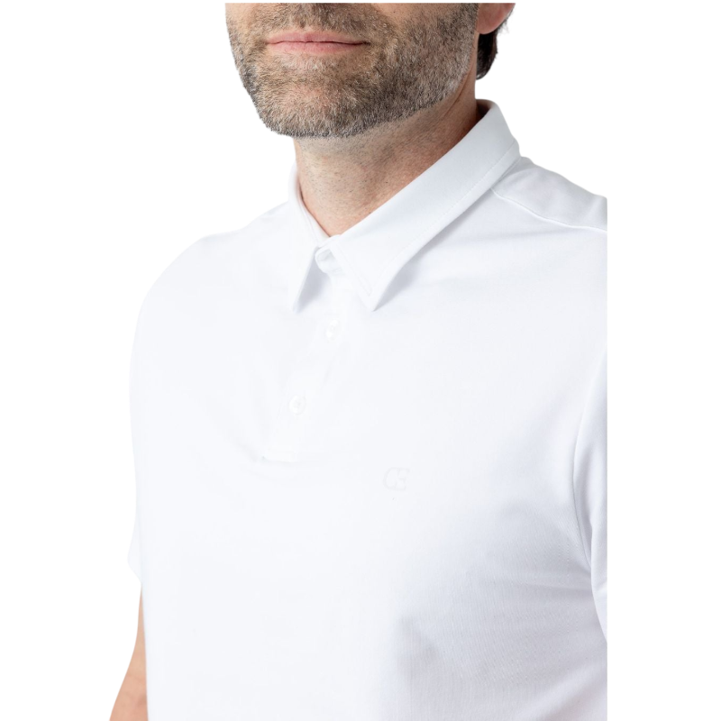 A person with short, light brown hair is wearing the Men's Everyday Polo by Cozy Earth in a light gray shade, paired with light beige pants. They are standing and slightly looking over their left shoulder with a neutral expression against a plain white background. |Color:Stone
