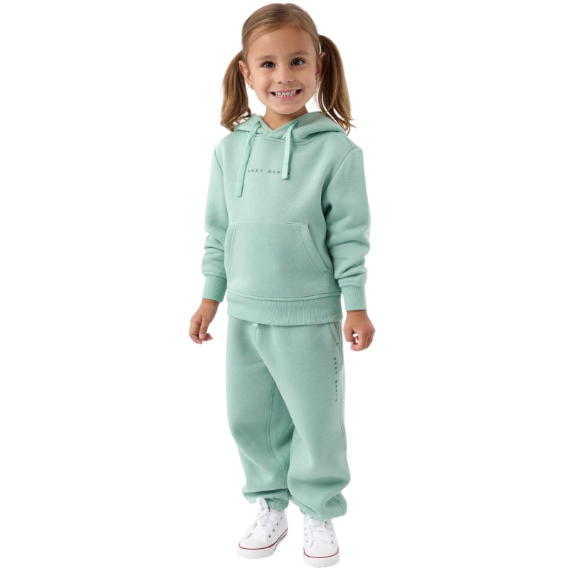 A young child with long blonde hair smiles while wearing a navy blue Kid's CityScape Hoodie by Cozy Earth and matching pants. She has two hair ties, one pink and one blue. The background is plain white. |Color:Eclipse