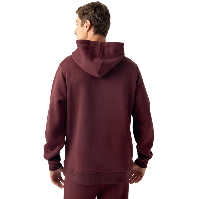 A person with curly hair is wearing a Cozy Earth Men's CityScape Hoodie in dark green and standing against a plain white background, with their hands together. |Color:Spruce