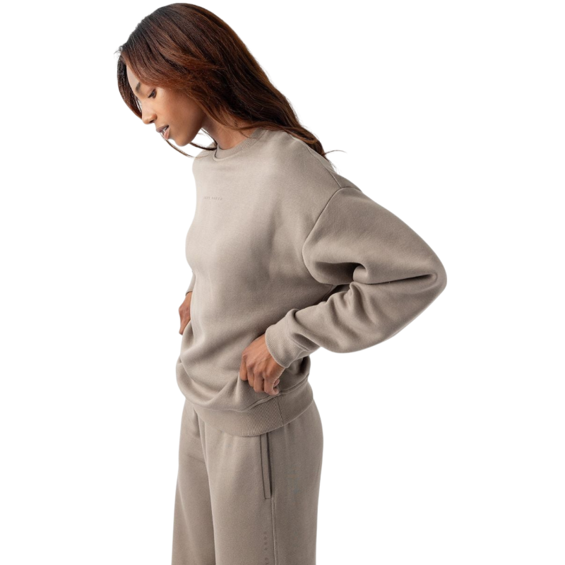 A person with curly hair models the Cozy Earth Women's CityScape Crewneck and matching pants in light pink against a plain white backdrop. |Color:Peony