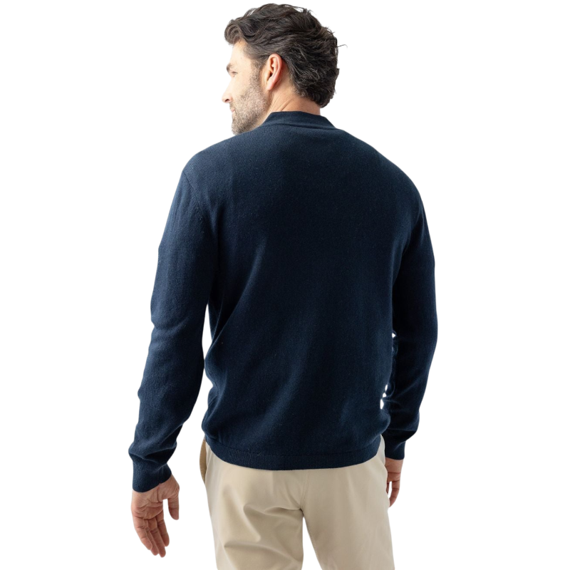 A man with dark hair and a short beard is wearing a navy blue Men's Quarter Zip Sweater from Cozy Earth paired with beige pants. He stands with his hands in his pockets against a plain white background, looking to his right with a slight smile. |Color:Eclipse