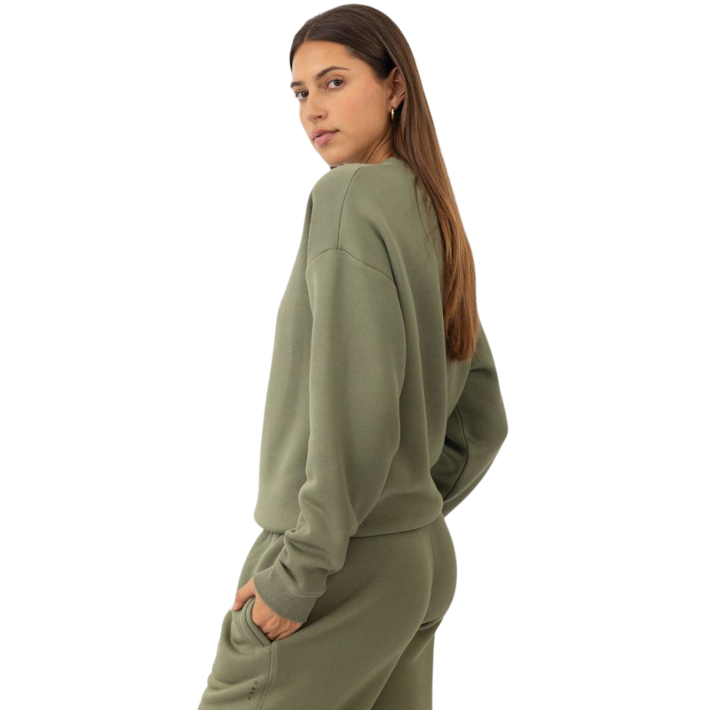 A person with curly hair models the Cozy Earth Women's CityScape Crewneck and matching pants in light pink against a plain white backdrop. |Color:Peony