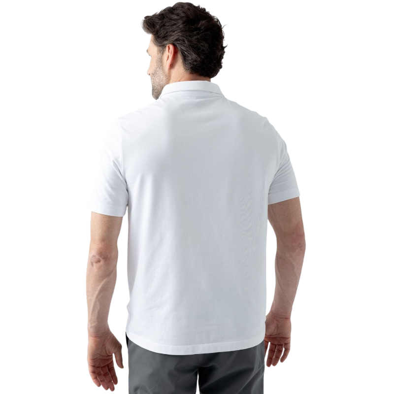 A person with short, light brown hair is wearing the Men's Everyday Polo by Cozy Earth in a light gray shade, paired with light beige pants. They are standing and slightly looking over their left shoulder with a neutral expression against a plain white background. |Color:Stone