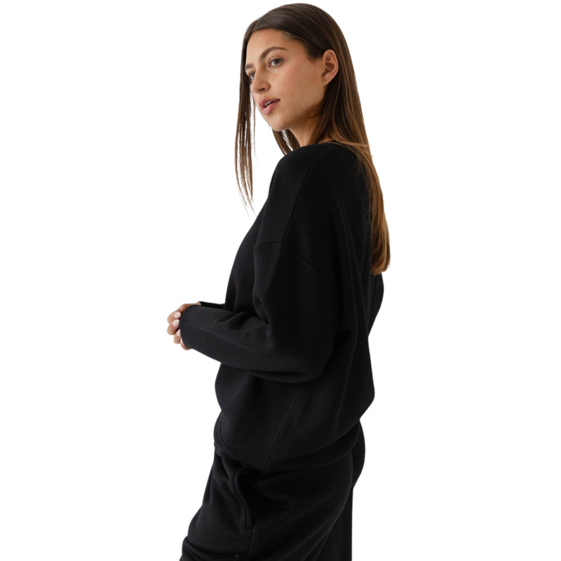 Black CityScape Pullover Crew. The Pullover is being worn by a female model. Accompanying city scape clothing is being worn to complete the look of the outfit. The photo was taken with a white background. |Color:Black