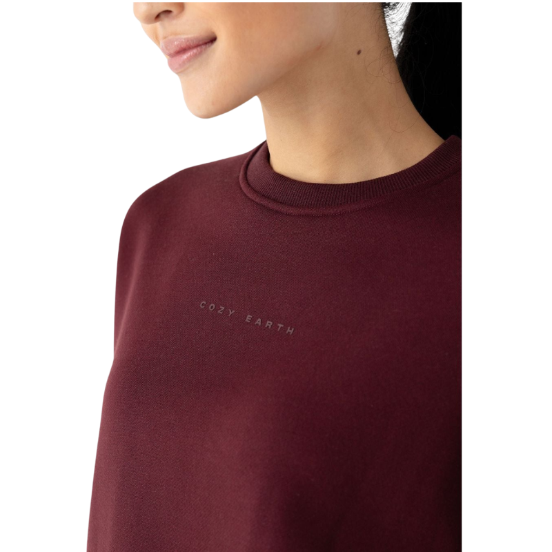 A person with curly hair models the Cozy Earth Women's CityScape Crewneck and matching pants in light pink against a plain white backdrop. |Color:Peony