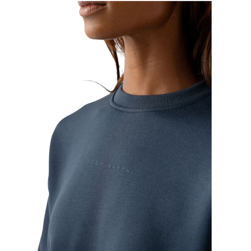 A person with curly hair models the Cozy Earth Women's CityScape Crewneck and matching pants in light pink against a plain white backdrop. |Color:Peony