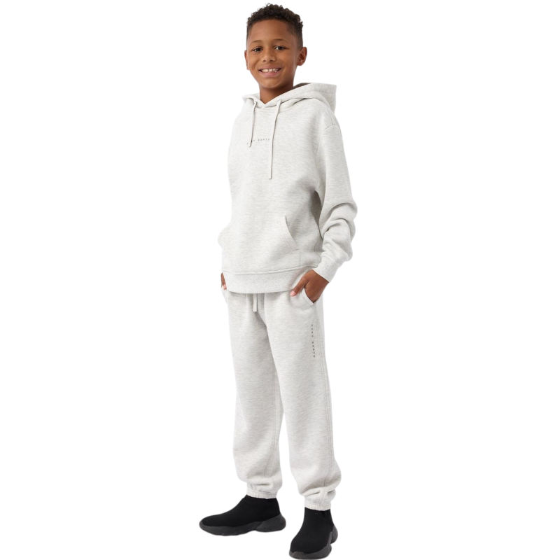 A young child with long blonde hair smiles while wearing a navy blue Kid's CityScape Hoodie by Cozy Earth and matching pants. She has two hair ties, one pink and one blue. The background is plain white. |Color:Eclipse