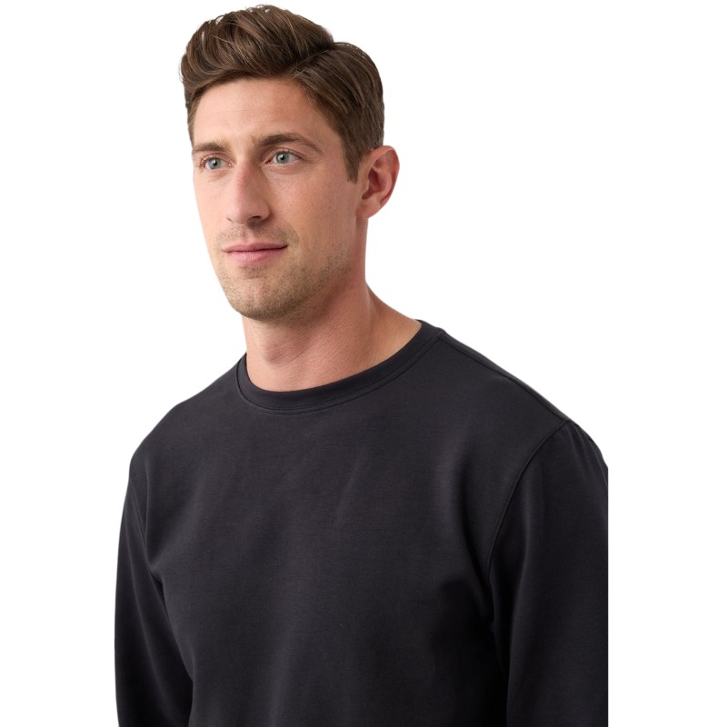 A man is wearing the Men's StretchTech Crewneck sweatshirt from Cozy Earth, paired with matching sweatpants. He stands against a plain white background with short brown hair, looking forward with a neutral expression. |Color:Coal Heather