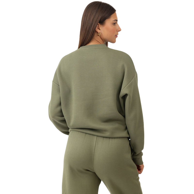 A person with curly hair models the Cozy Earth Women's CityScape Crewneck and matching pants in light pink against a plain white backdrop. |Color:Peony