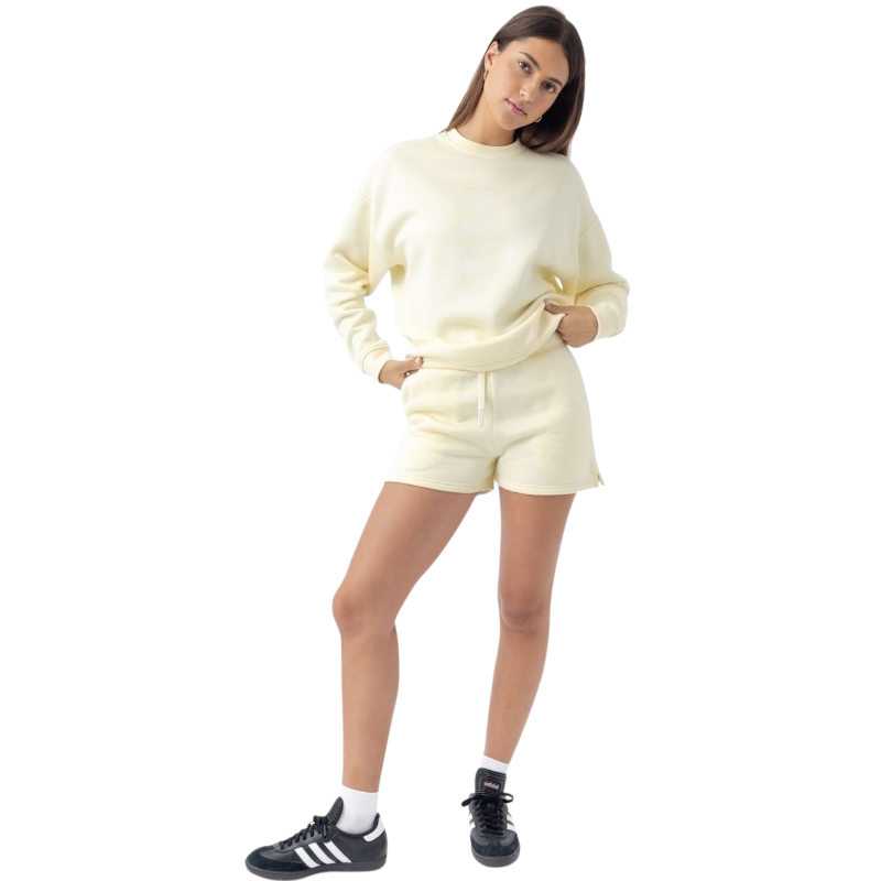 A person with curly hair models the Cozy Earth Women's CityScape Crewneck and matching pants in light pink against a plain white backdrop. |Color:Peony