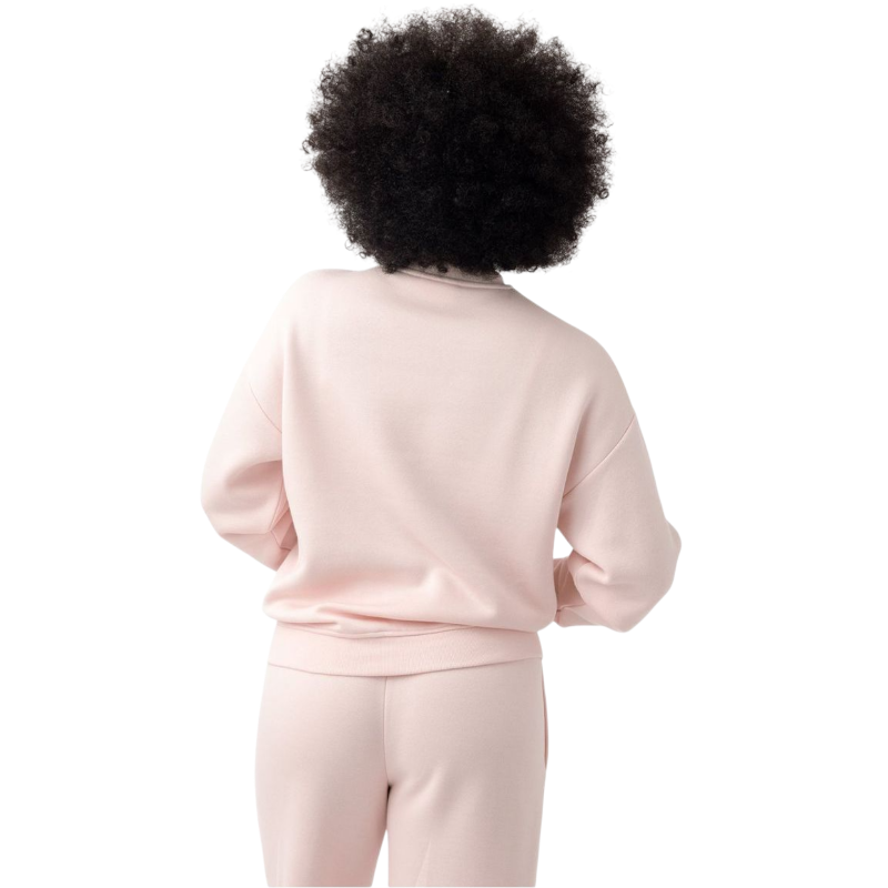 A person with curly hair models the Cozy Earth Women's CityScape Crewneck and matching pants in light pink against a plain white backdrop. |Color:Peony
