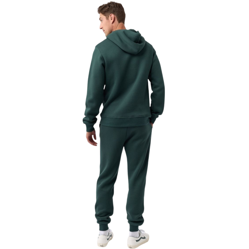 A person with curly hair is wearing a Cozy Earth Men's CityScape Hoodie in dark green and standing against a plain white background, with their hands together. |Color:Spruce