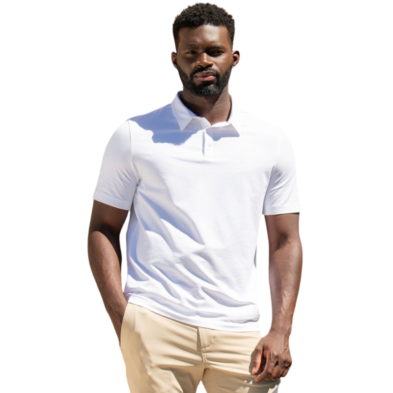 A person with short, light brown hair is wearing the Men's Everyday Polo by Cozy Earth in a light gray shade, paired with light beige pants. They are standing and slightly looking over their left shoulder with a neutral expression against a plain white background. |Color:Stone
