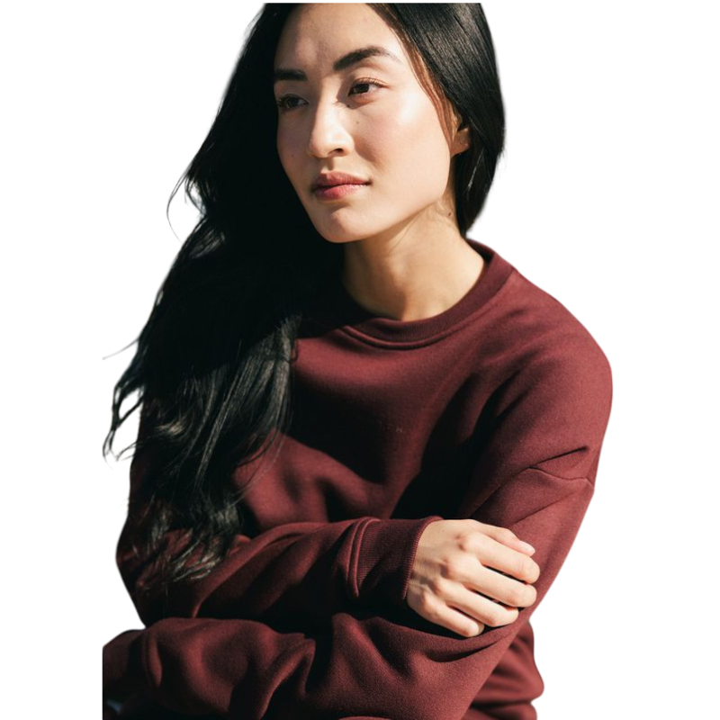 A person with curly hair models the Cozy Earth Women's CityScape Crewneck and matching pants in light pink against a plain white backdrop. |Color:Peony