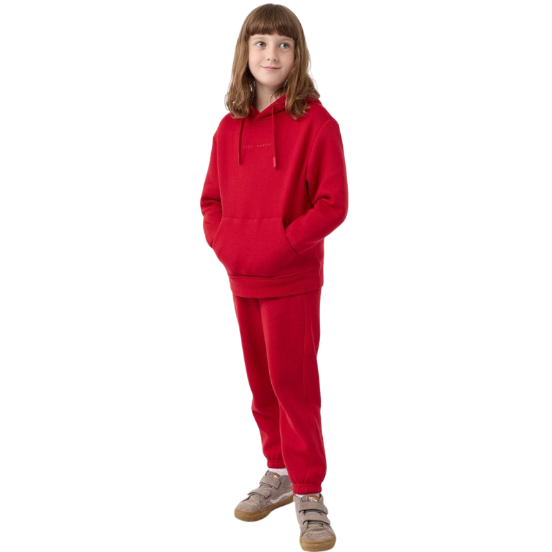 A young child with long blonde hair smiles while wearing a navy blue Kid's CityScape Hoodie by Cozy Earth and matching pants. She has two hair ties, one pink and one blue. The background is plain white. |Color:Eclipse