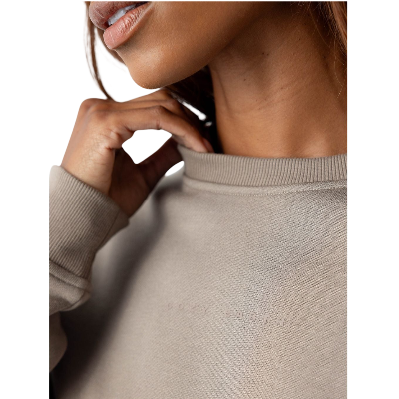 A person with curly hair models the Cozy Earth Women's CityScape Crewneck and matching pants in light pink against a plain white backdrop. |Color:Peony