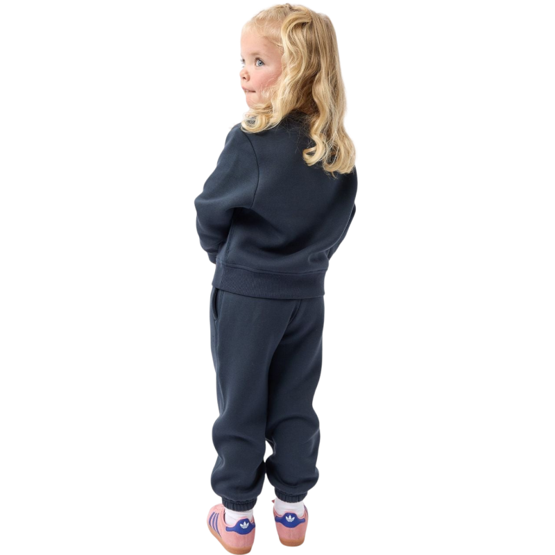 A young boy with blond hair is wearing the Cozy Earth Kid's CityScape Crewneck sweatshirt along with matching pants. He is standing, smiling, and looking slightly to the side against a plain white background. |Color:Eclipse