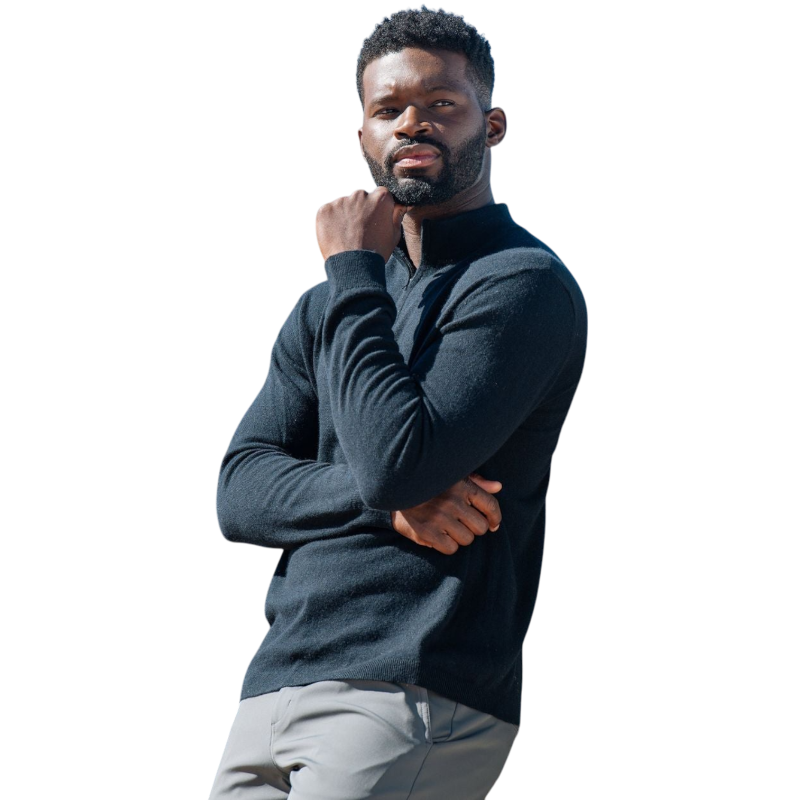 A man with dark hair and a short beard is wearing a navy blue Men's Quarter Zip Sweater from Cozy Earth paired with beige pants. He stands with his hands in his pockets against a plain white background, looking to his right with a slight smile. |Color:Eclipse
