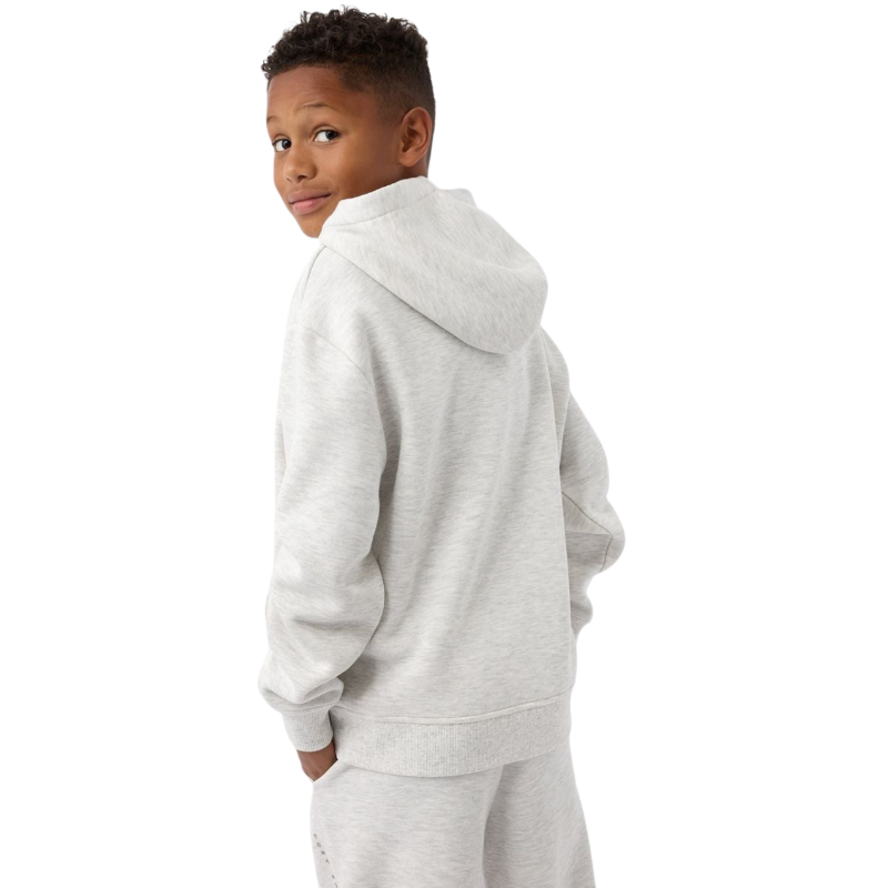 A young child with long blonde hair smiles while wearing a navy blue Kid's CityScape Hoodie by Cozy Earth and matching pants. She has two hair ties, one pink and one blue. The background is plain white. |Color:Eclipse