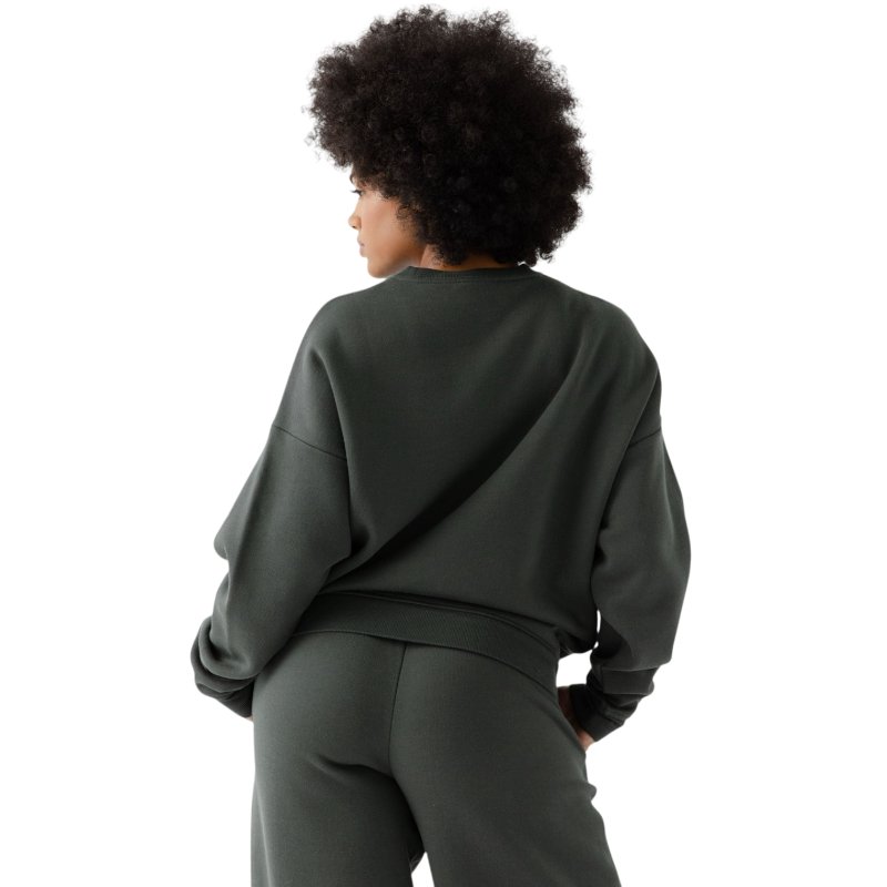 A person with curly hair models the Cozy Earth Women's CityScape Crewneck and matching pants in light pink against a plain white backdrop. |Color:Peony