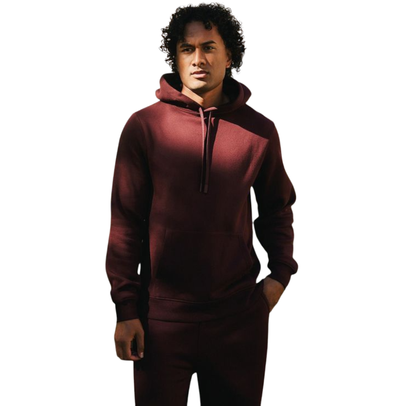 A person with curly hair is wearing a Cozy Earth Men's CityScape Hoodie in dark green and standing against a plain white background, with their hands together. |Color:Spruce