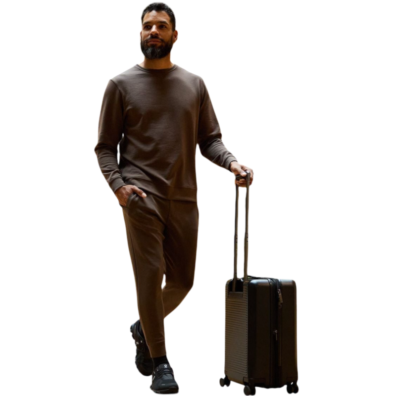 A man is wearing the Men's StretchTech Crewneck sweatshirt from Cozy Earth, paired with matching sweatpants. He stands against a plain white background with short brown hair, looking forward with a neutral expression. |Color:Coal Heather