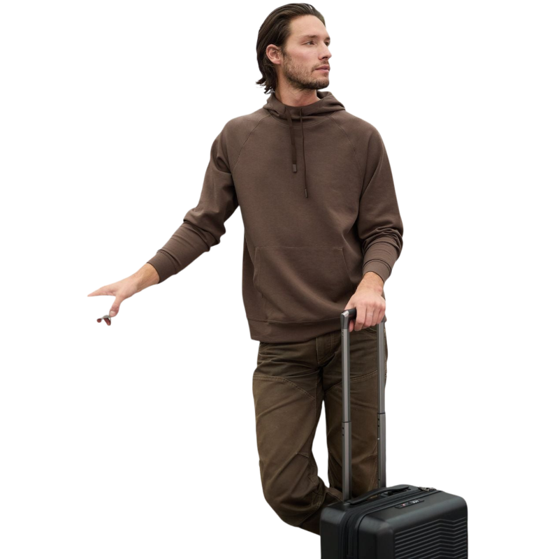 A person wearing the Men's StretchTech Hoodie from Cozy Earth, paired with matching gray pants, stands against a plain white background. The hoodie features drawstrings and a front pocket. The individual is looking forward with a neutral expression. |Color:Coal Heather