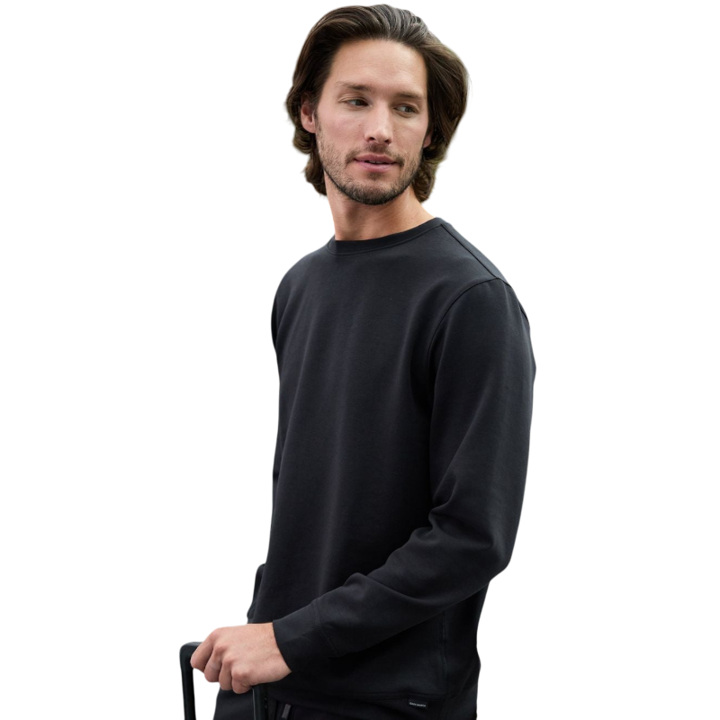 A man is wearing the Men's StretchTech Crewneck sweatshirt from Cozy Earth, paired with matching sweatpants. He stands against a plain white background with short brown hair, looking forward with a neutral expression. |Color:Coal Heather