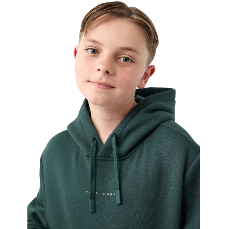 A young child with long blonde hair smiles while wearing a navy blue Kid's CityScape Hoodie by Cozy Earth and matching pants. She has two hair ties, one pink and one blue. The background is plain white. |Color:Eclipse