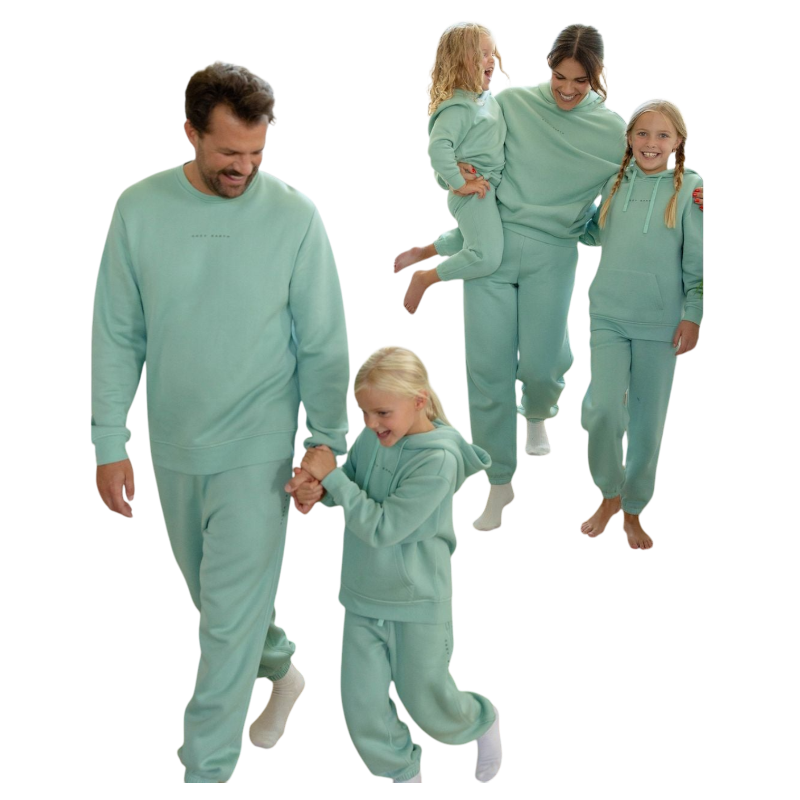 A young boy with blond hair is wearing the Cozy Earth Kid's CityScape Crewneck sweatshirt along with matching pants. He is standing, smiling, and looking slightly to the side against a plain white background. |Color:Eclipse