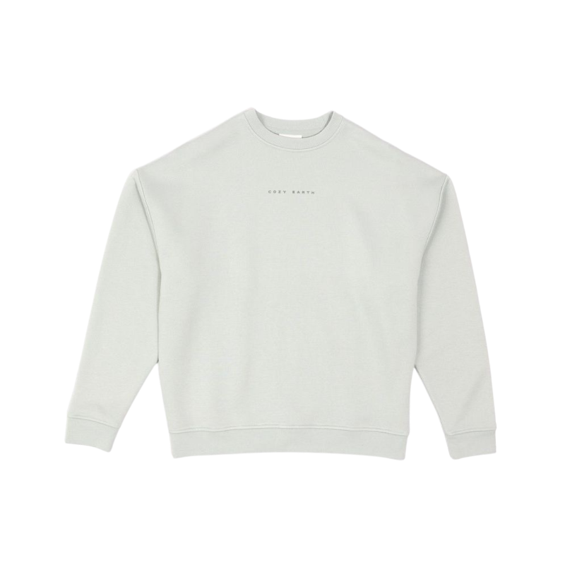 A person with curly hair models the Cozy Earth Women's CityScape Crewneck and matching pants in light pink against a plain white backdrop. |Color:Peony