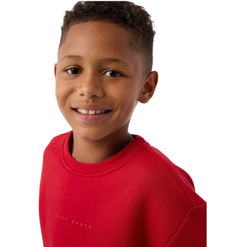 A young boy with blond hair is wearing the Cozy Earth Kid's CityScape Crewneck sweatshirt along with matching pants. He is standing, smiling, and looking slightly to the side against a plain white background. |Color:Eclipse