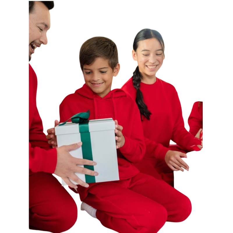 A young child with long blonde hair smiles while wearing a navy blue Kid's CityScape Hoodie by Cozy Earth and matching pants. She has two hair ties, one pink and one blue. The background is plain white. |Color:Eclipse