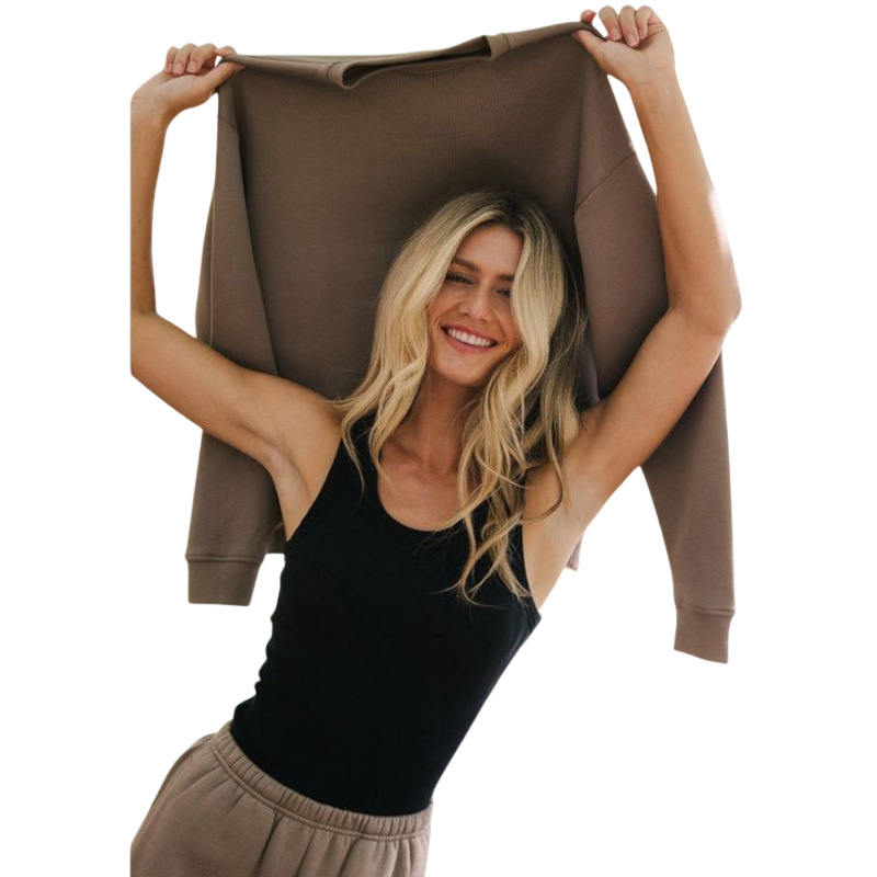 A person with curly hair models the Cozy Earth Women's CityScape Crewneck and matching pants in light pink against a plain white backdrop. |Color:Peony